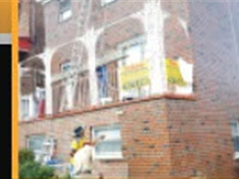 Tekno Construction crew restoring a brick apartment building exterior