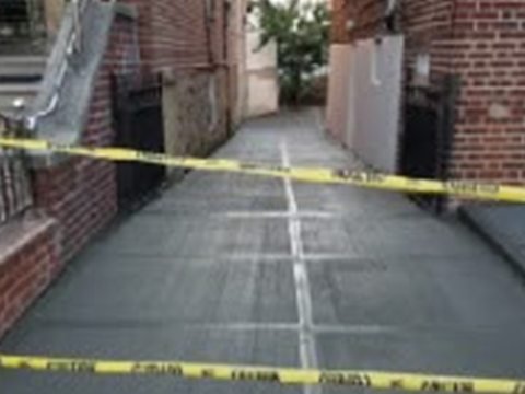 Freshly poured concrete sidewalk with DOT caution tape completed by Tekno Construction in NYC
